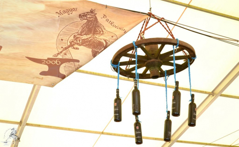 A Németh János Pincészet borospalackjai a sátor tetején függő kocsikerékről lógnak le